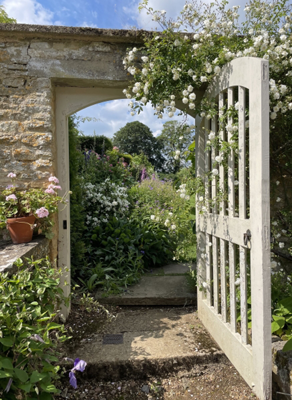 An open gate in the garden wall at Dean Manor.