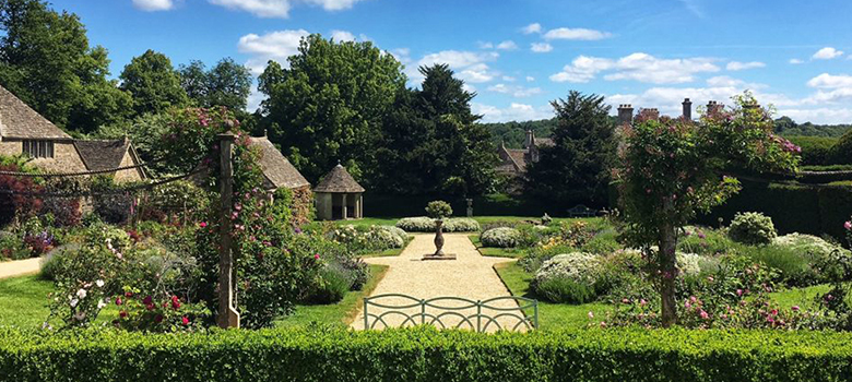 A view across the semi-formal gardens at Miserden Park, including a wide range of plants and shrubs.