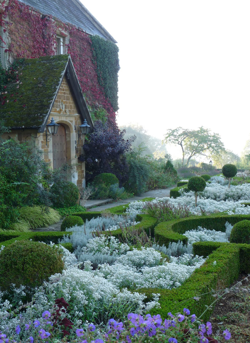 The beautiful entrance to Broughton Grange with impressive formal topiary and flowers.